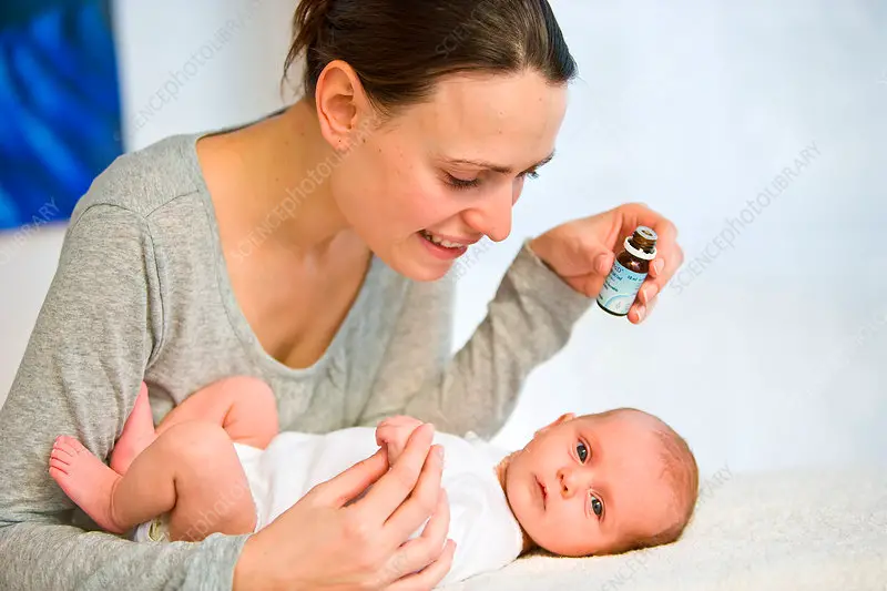 Mother giving vitamin D to baby